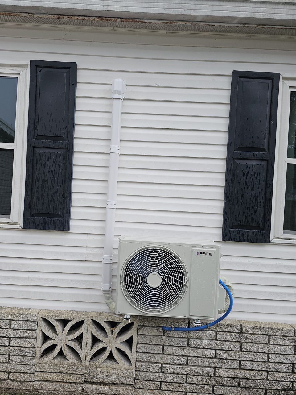 Ductless mini-split AC installation, outdoor unit mounted on the foundation with line-set cover