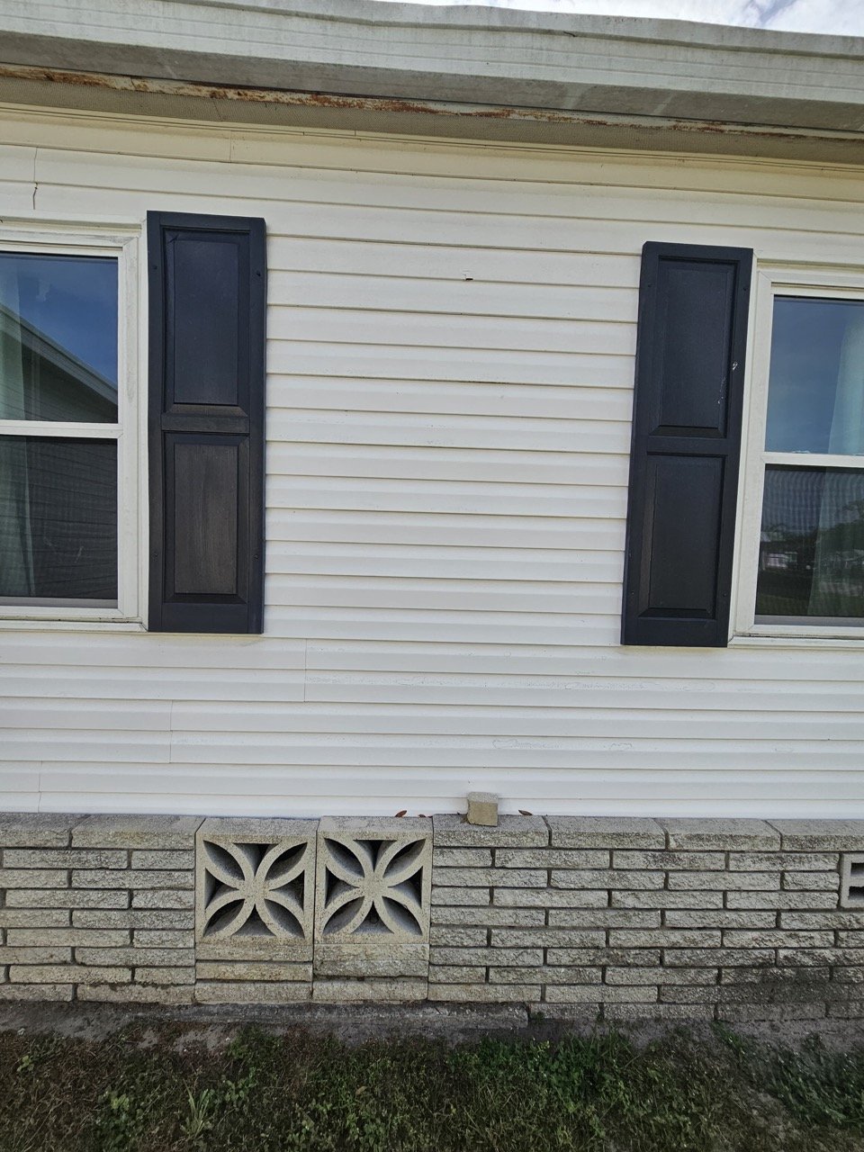 Exterior vinyl siding and shutters before mini-split installation